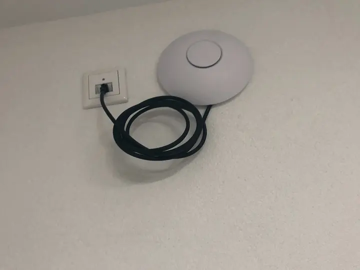 Access Point an der Wand, das Patchkabel hängt als lose Schlaufe